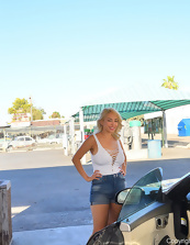 Classy blonde in sexy shorts seductively washes her cabriolet