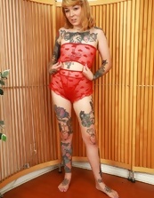 Tattooed minx takes off red panties to show her bush