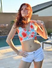 Slim redhead in sexy shorts shows her tits outdoors