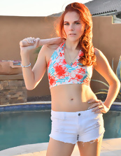 Slim redhead in sexy shorts shows her tits outdoors