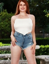 Curvy redhead in denim shorts shows her bush outdoors