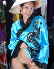 Fit and hot Asian brunette is wearing a mask and a kimono