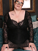 Mature milf nude solo tease with glasses, shaved pussy and sagging tits in spread pose