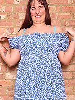 Mature brunette milf in blue dress teases with natural tits, hairy pussy, spread pose